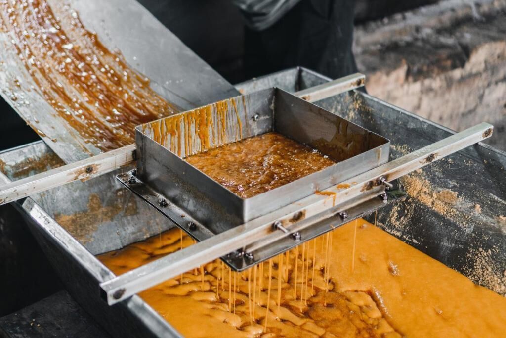 A metal trough with a liquid substance being poured into it.