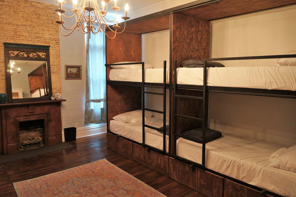 Quarto com beliches, lareira e um lustre.