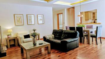 Una sala moderna con sofá, mesa de centro y comedor con sillas y mesa.