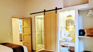 A hotel room with a bed, a bathroom with a sink and mirror, and a closet with a sliding door. - Casa Donceles Apartments & Suites, Alojamientos ideales para familias y grupos (Mexico City)