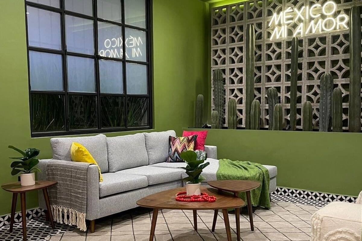 Una sala de estar acogedora con un sofá gris, una mesita de centro y una pared verde.