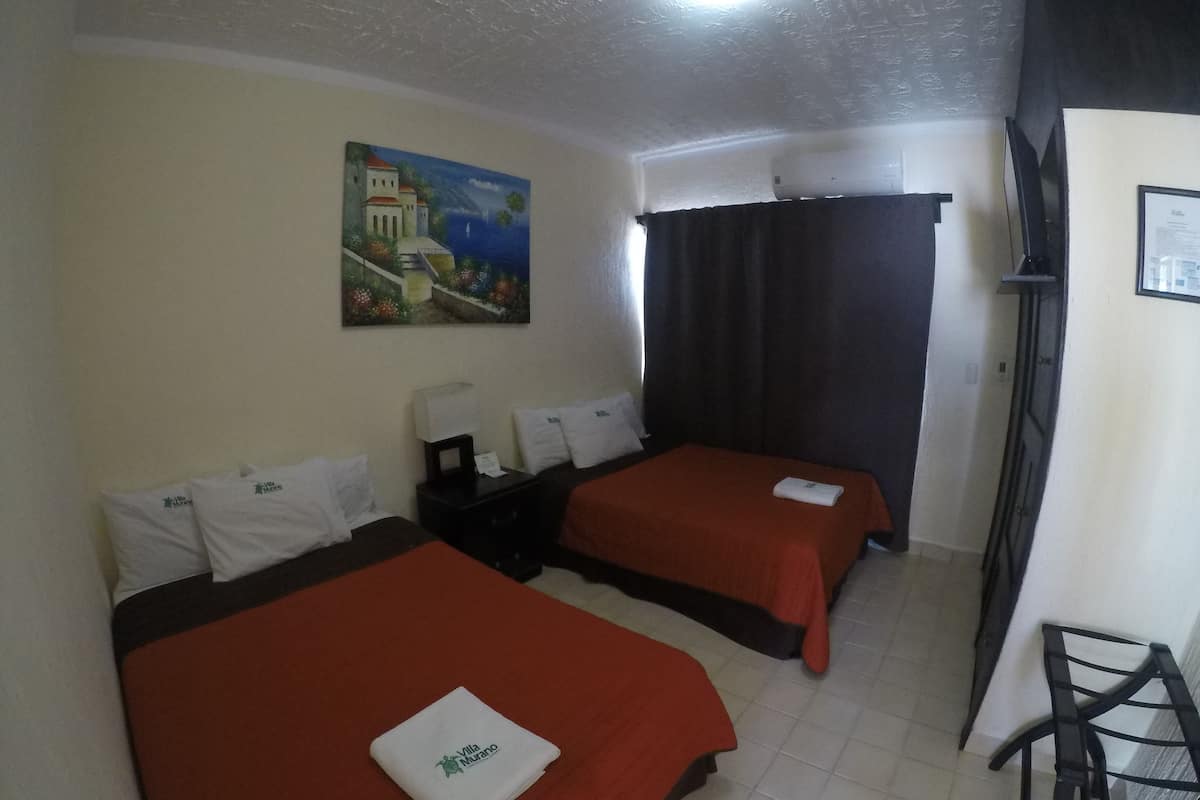 Een hotelkamer met twee bedden, een schilderij aan de muur, een televisie en een bureau met een lamp.