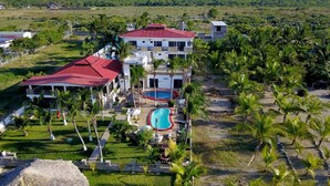 A large resort with multiple buildings, a swimming pool, and palm trees. - Hotel Villa Murano (Tonalá)