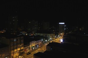 A nighttime cityscape with illuminated buildings and a street. - Geneviee Palace Hotel (Ponta Grossa)