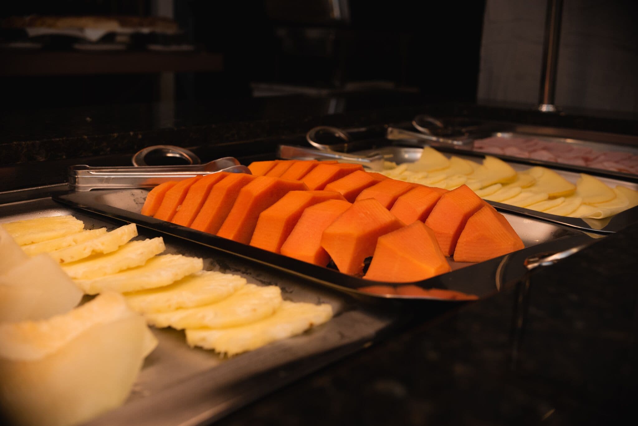 A buffet with various food items including sliced carrots, potatoes, and other vegetables.