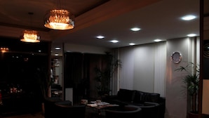 Un salon moderne avec un ensemble de canapés, une table basse et des luminaires suspendus.