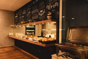 A buffet area with a variety of food items, including pastries and beverages, and a chalkboard wall with motivational phrases. - Geneviee Palace Hotel (Ponta Grossa)