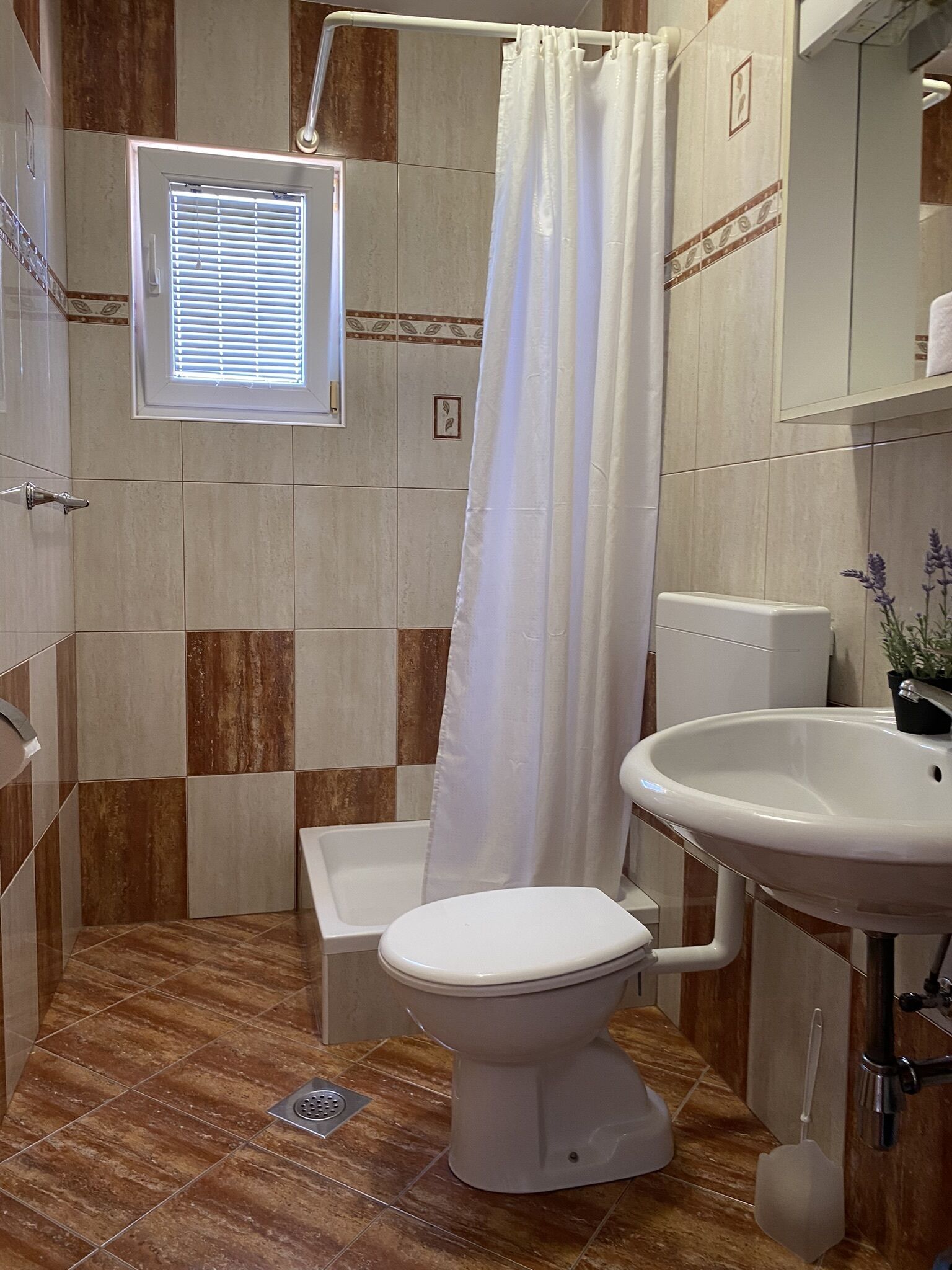 Ein Badezimmer mit Dusche, Toilette und Waschbecken.