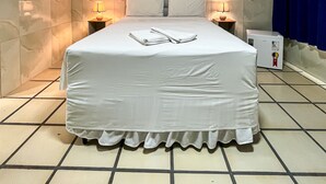A neatly made bed with a white bedspread and pillows, a wall-mounted air conditioner, and a bedside table with a lamp. - Sonho de Iracema Hostel Boutique (Fortaleza)
