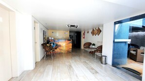 A spacious living area with a wooden floor, a central painting, and a seating area with chairs and a small table. - Sonho de Iracema Hostel Boutique (Fortaleza)