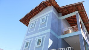 A building with a blue-tiled facade, a balcony with a metal railing, and a red-tiled roof. - Sonho de Iracema Hostel Boutique (Fortaleza)