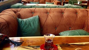 Een ontbijtsetting met een bord eten, inclusief eieren, groenten en een bagel, op een houten tafel.