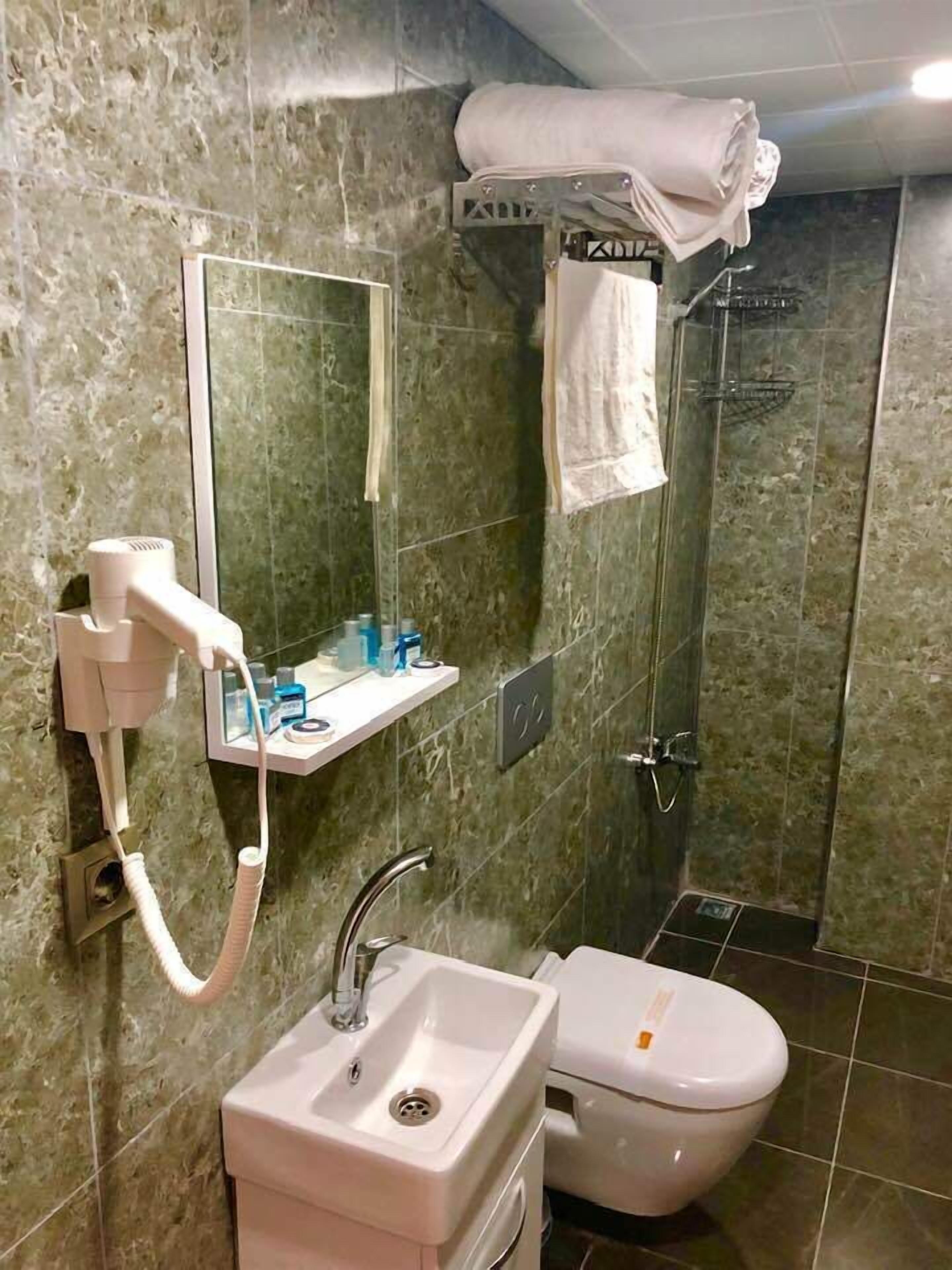Un baño con lavamanos, inodoro y zona de ducha.