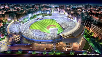 A stadium with a baseball field, surrounded by modern buildings and a cityscape at night.