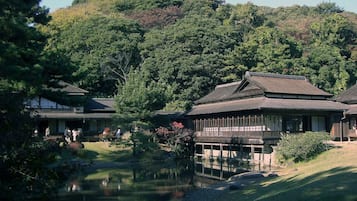 A traditional Japanese-style building with a wooden structure and a pond in front.