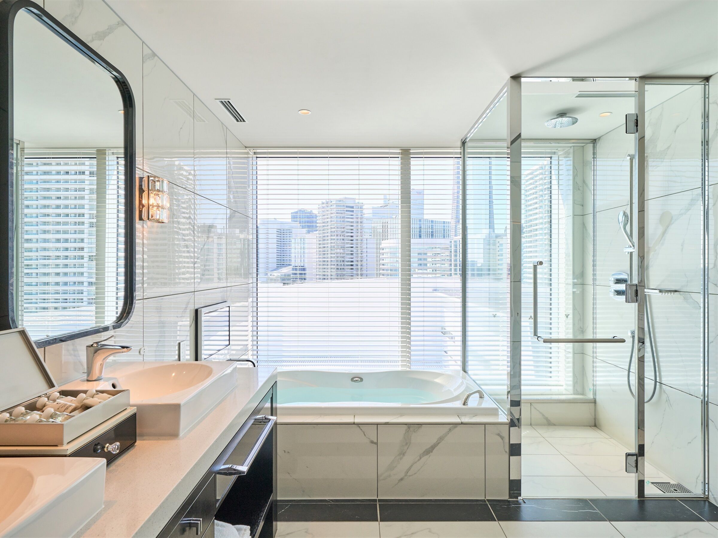 A modern bathroom with a large bathtub, a vanity with a mirror, and a shower area.