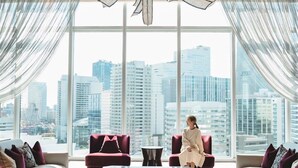 A modern interior with large windows, red sofas, and a city view.