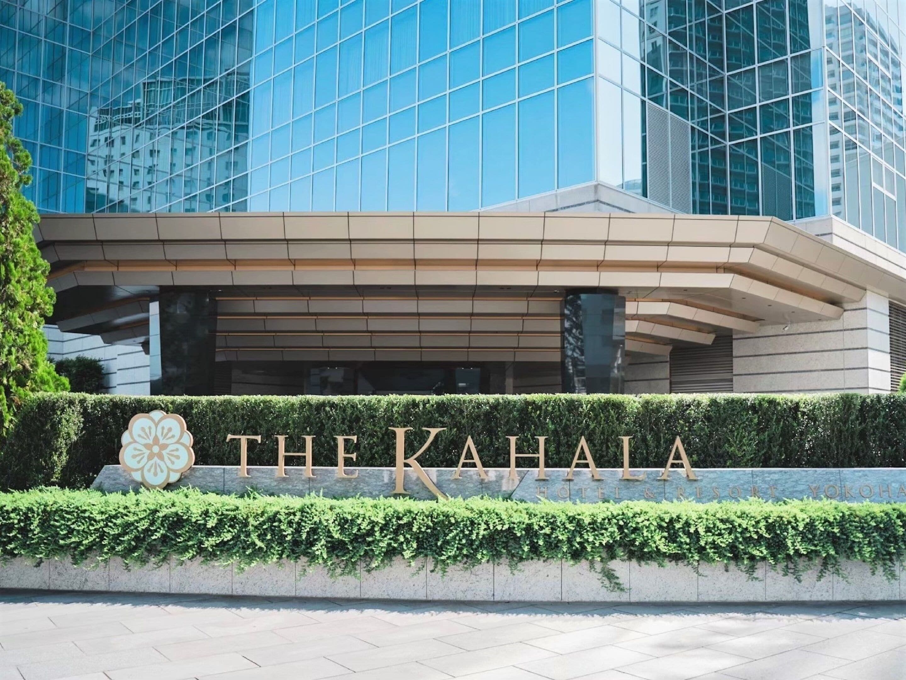 A modern building with a glass facade and a sign that reads "THE KAHALA HOTEL & RESORT".