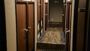 Pasillo de hotel con varias puertas, pisos alfombrados y una escalera que lleva a un nivel superior.