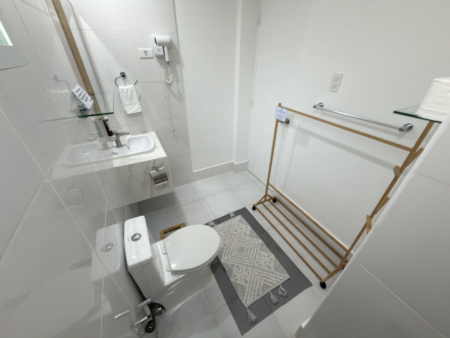 A modern bathroom with a toilet, sink, and glass shower enclosure.