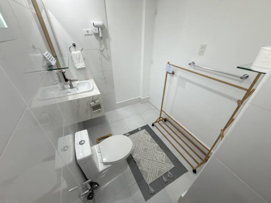 Un baño moderno con inodoro, lavabo y cabina de ducha de vidrio.