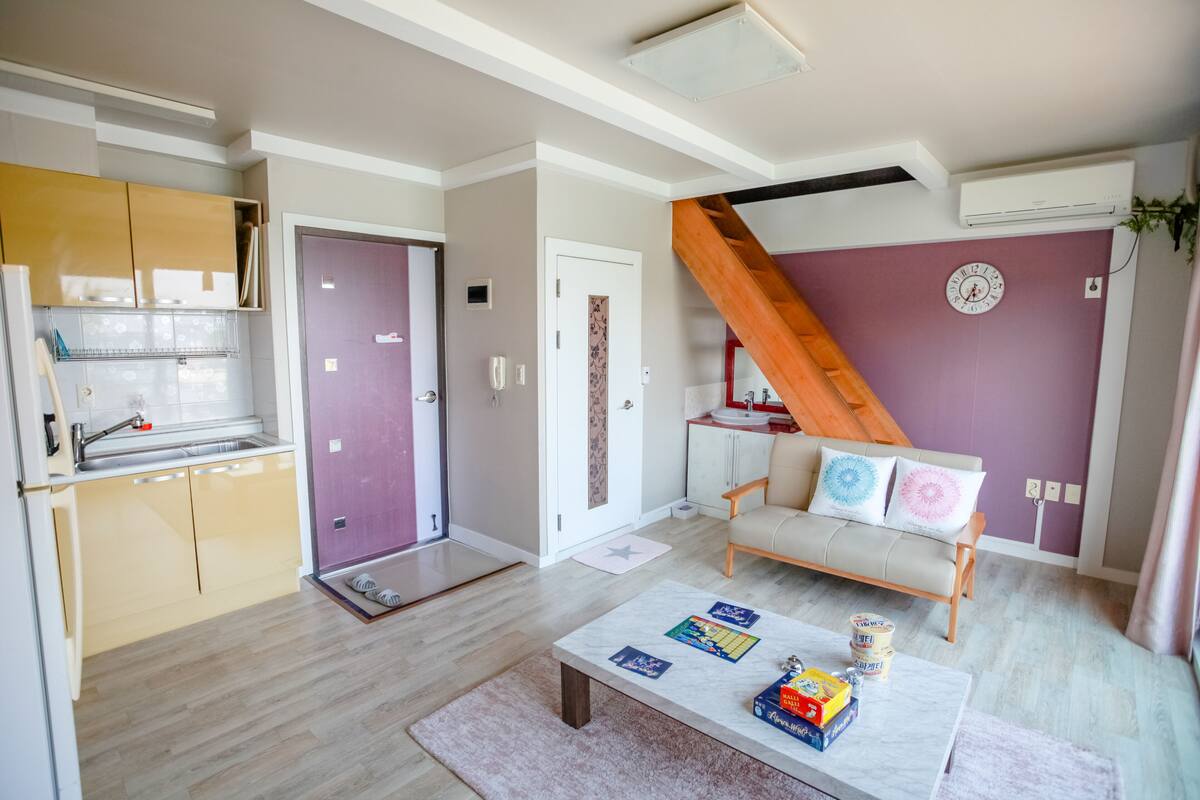 Un apartamento moderno con cocina, sala de estar y una escalera.