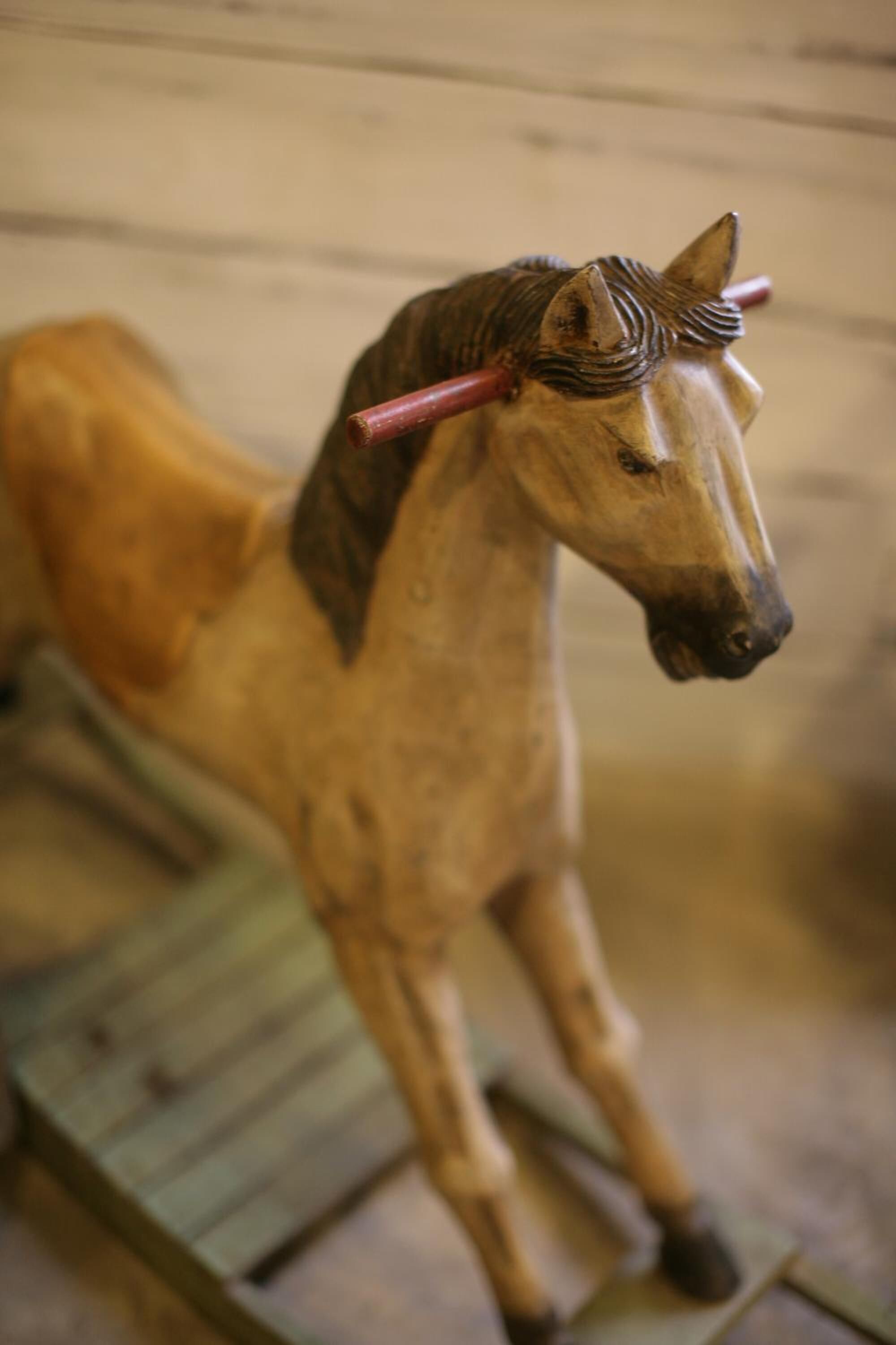 Una statuina di un cavallo di legno montata su una struttura in legno.