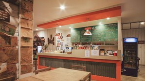 A restaurant interior with a counter, menu, and seating area. - Ted's Bed and Breakfast (Santa Cruz)