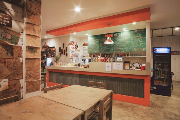 A restaurant interior with a counter, menu, and seating area. - Ted's Bed and Breakfast (Santa Cruz)