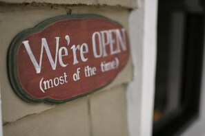 A sign that reads "We're OPEN (most of the time)" on a building wall. - Ted's Bed and Breakfast (Santa Cruz)
