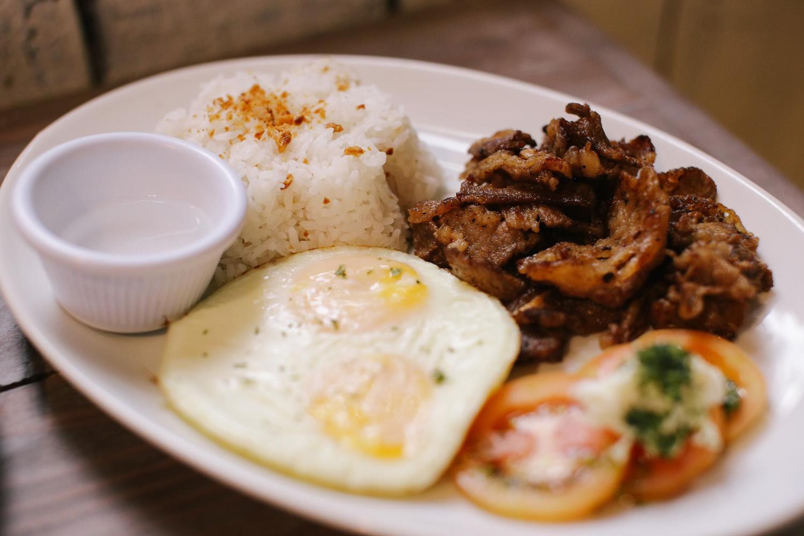 A plate with white rice, fried egg, and grilled meat.