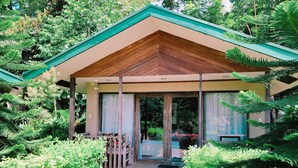 A wooden-roofed building with a glass entrance, surrounded by lush greenery. - Ted's Bed and Breakfast (Santa Cruz)