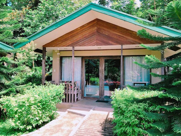 A wooden-roofed building with a glass entrance, surrounded by lush greenery. - Ted's Bed and Breakfast (Santa Cruz)