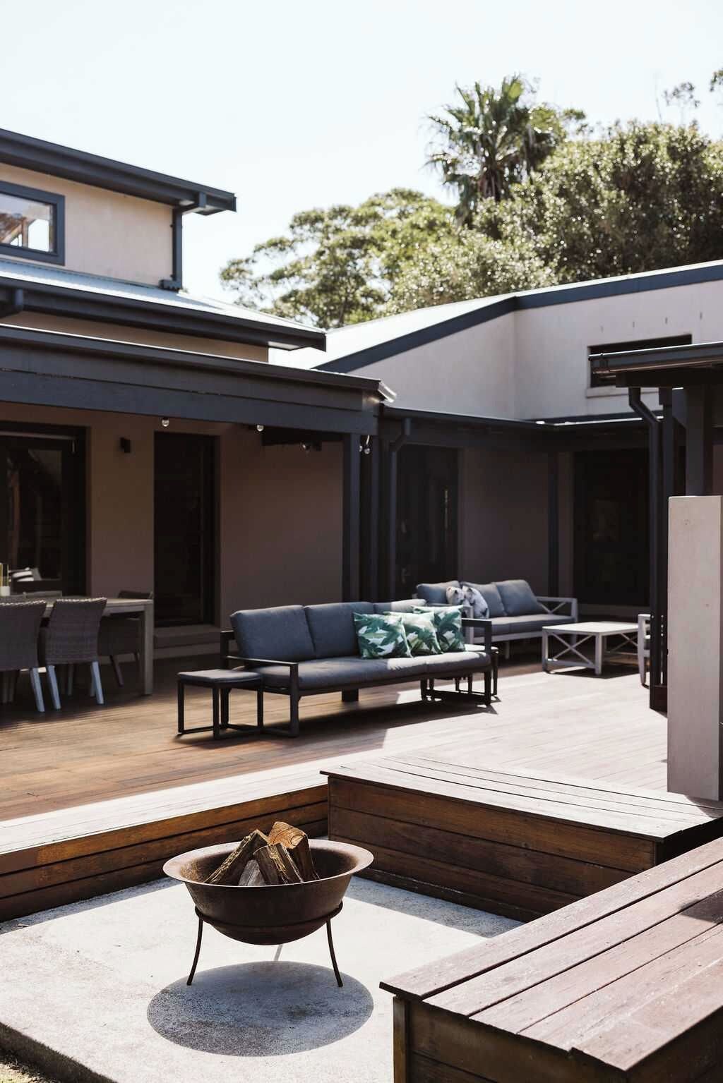 An outdoor patio area with a fire pit, seating, and a dining table.