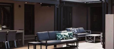 An outdoor patio area with a fire pit, seating, and a dining table.