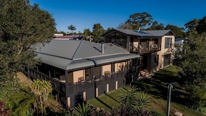 A modern two-story house with a large deck and a covered outdoor area. - The Agave (Currarong)