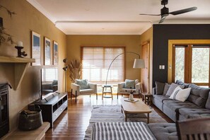 A living room with a fireplace, sofas, a coffee table, and a TV.
