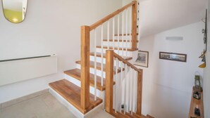 A staircase with wooden steps and white railings, leading to an upper floor. - Lady Lavender by Interhome (Mrkopalj)
