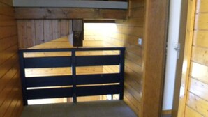 A stable interior with a wooden floor, a black gate, and wooden walls. - P4 Duplex BELLECOMBE area of DIAMOND SPACE (Notre-Dame-De-Bellecombe)