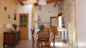 A dining area with a wooden table, chairs, and a cabinet. - Apartment in a quiet village house (Colonzelle)