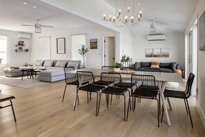 Relax in this open-plan living space with a dining area, cozy seating, and a large window.