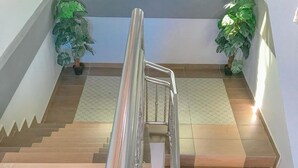 A staircase with a metal handrail, wooden steps, and potted plants at the top and bottom. - Norshah Village Resort (Langkawi)