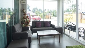 A modern living room with a sofa, armchair, and coffee table. - Norshah Village Resort (Langkawi)