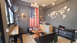 Un interior moderno con una zona de estar, un mapa mundial en la pared y una gran bandera estadounidense.