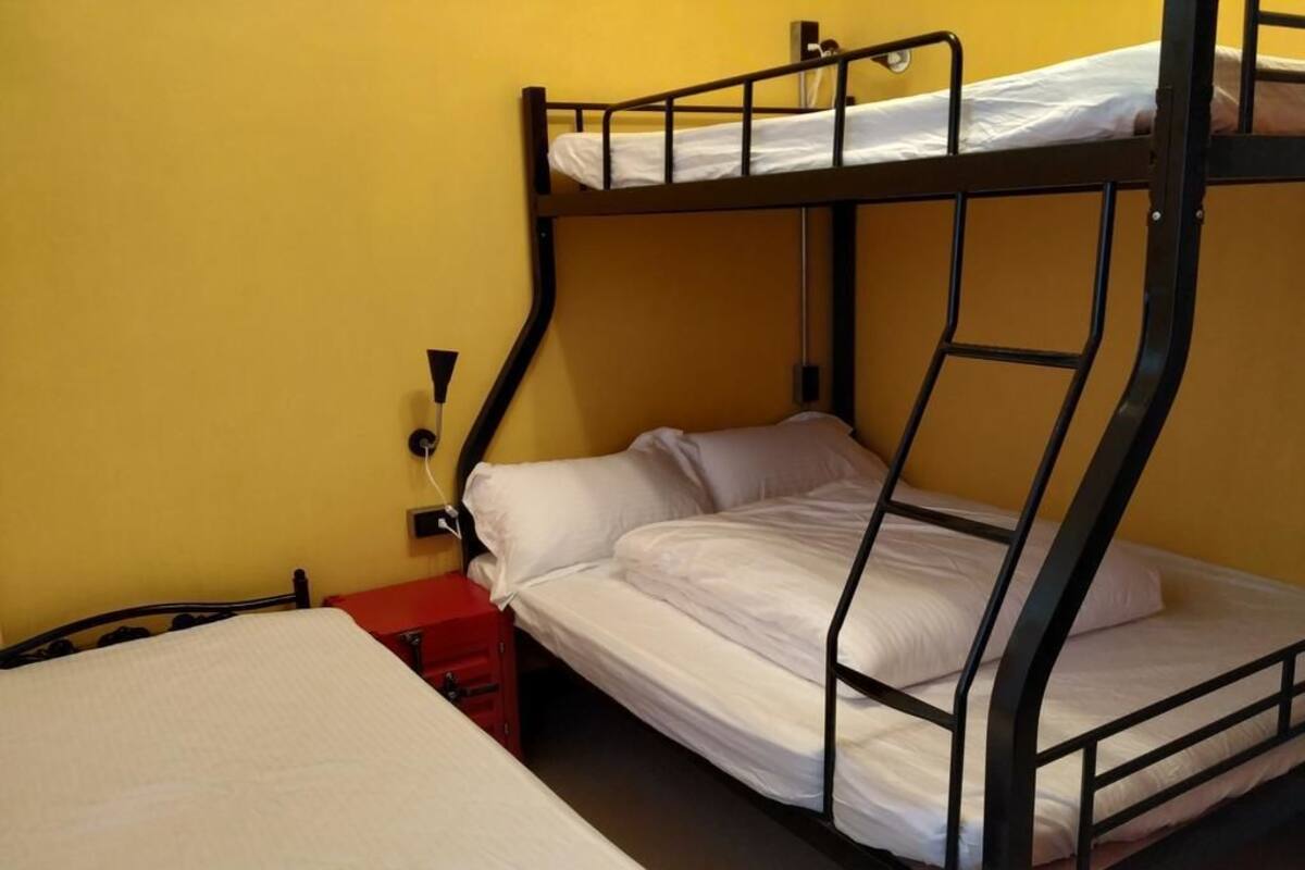 A bunk bed room with a single bed on the left and a bunk bed on the right.