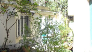 Un patio con plantas en macetas y un edificio con balcón.