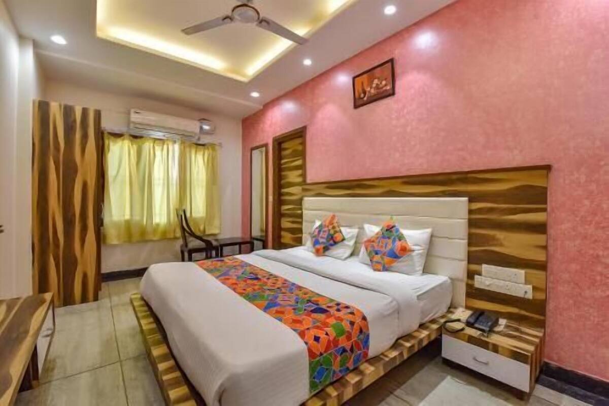 Ein Hotelzimmer mit Bett, Nachttisch und Deckenventilator.