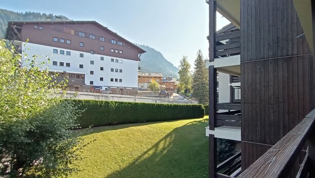 A modern building with a balcony, a well-maintained lawn, and a mountain backdrop. - 1 RR6171 - (Megève)