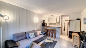 A compact living space with a sofa, a coffee table, and a kitchenette area. - 1 RR6171 - (Megève)
