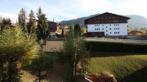 A building with a flat roof and multiple windows, surrounded by trees and a grassy area. - 1 RR6171 - (Megève)